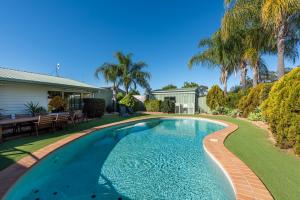a swimming pool in the yard of a house at Chinchilla Tourist Park in Chinchilla