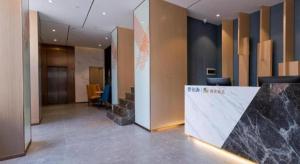 a lobby of an office with a counter and chairs at ZMAX Hotels Shenzhen Lianhuacun Metro Station in Shenzhen