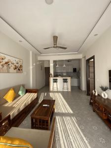 a living room with a couch and a table at Chic 1BHK Apartment - Pool, Gym, Amenities Near Candolim Beach in Candolim