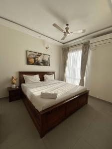 a bedroom with a large bed and a window at Chic 1BHK Apartment - Pool, Gym, Amenities Near Candolim Beach in Candolim