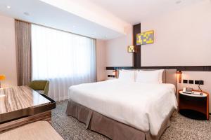 a hotel room with a large bed and a window at Nathan Hotel in Hong Kong