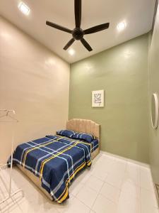 a bedroom with a bed and a ceiling fan at Homestay Kuala Perlis in Kuala Perlis