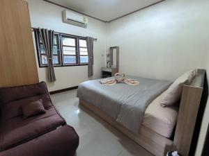 a bedroom with a bed and a couch at Bp HOUSE in Nakhon Phanom