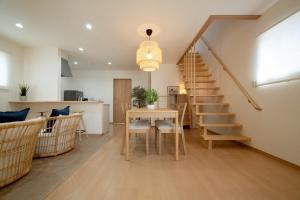 a living room with a dining room table and stairs at Villa Gotemba Retreat in Gotemba