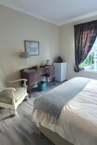 MuizenbergにあるSufi'Sawd Guest Rooms Muizenbergのベッドと机と窓のある寝室
