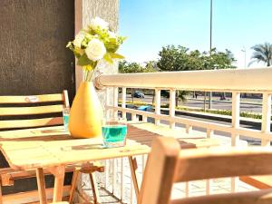 a wooden table with a vase of flowers on a balcony at Stunning and warm near East Hub in Madinaty in Madinaty +4 photos