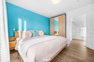 ein Schlafzimmer mit einem großen Bett mit einer blauen Wand in der Unterkunft Meerverliebt in Büsum