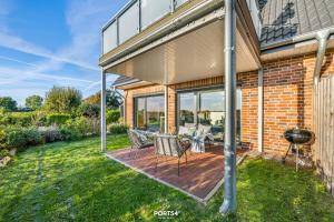 eine Terrasse mit Tisch und Stühlen auf einem Deck in der Unterkunft Meerverliebt in Büsum