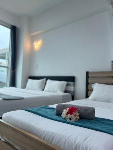 a hotel room with two beds with flowers on them at Sutera Avenue Kota Kinabalu City Centre LW Suites in Kota Kinabalu +49 photos
