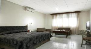 a bedroom with a bed and a couch and a television at Hotel Griyadi Kusuma Sahid in Solo +57 photos
