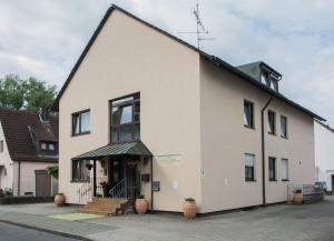 a white building with a black roof at Hotel Avenue Altenfurt in Nürnberg