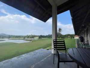 un porche avec des chaises et une vue sur un lac dans l'établissement Deluxe Room Sea View Pool Golf Nuvasa Bay Kalani Tower, à Pulau Nongsa