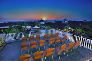 a group of chairs sitting on a balcony at night at favehotel Kuta Kartika Plaza in Kuta
