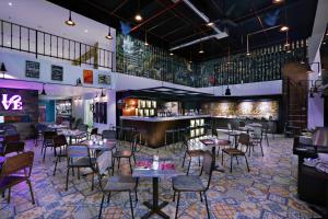 a restaurant with tables and chairs and a bar at favehotel Kuta Kartika Plaza in Kuta