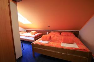 2 camas en una habitación pequeña con paredes de color naranja en B&B Kolarić, en Jastrebarsko