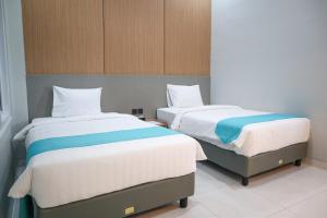 two beds in a room with two beds sidx sidx sidx at Commodious Hotel Kupang in Klapalima