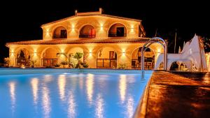 a large building with a swimming pool at night at Villa Sunset B&B/Apartments in Fontane Bianche +22 photos