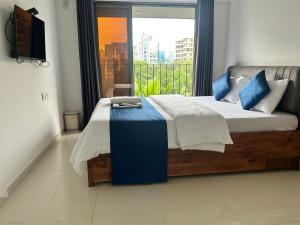 a bedroom with a large bed with a window at Zenith Homes - Elite Suites , Near Chhatrapati Shivaji Maharaj International Airport Mumbai in Mumbai