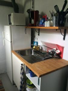 uma cozinha com um lavatório e um suporte para pratos num balcão em Vita Lilla Stugan i Vimmerby em Vimmerby