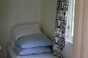 a bed with a white comforter next to a window at Volsdalen Camping in Ålesund