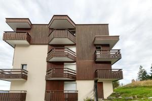 a building with balconies on the side of it at Le May'hé - Studio Cabine Et Balcon in Les Adrets