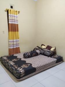 un letto posto all'ultimo piano in una stanza di 563 Homestay Jogja a Ngabean
