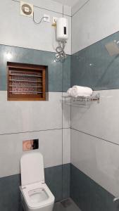 a bathroom with a toilet and a glass shower at Grand Beach Villa in Kannur