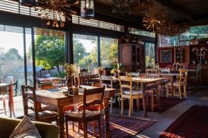 a restaurant with tables and chairs and large windows at ECO Lodge Villa Villekula in The Crags