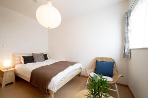 a bedroom with a bed and a chair at Villa Gotemba Retreat in Gotemba