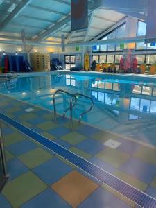 a large swimming pool in a building at 2 Bedroom Mini Lodge near the beach in Walton-on-the-Naze