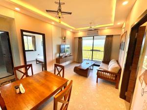 Una sala de estar con una mesa de comedor y un sofá. en Vintage 2BHK Apartment - Gym, Pool & Amenities - Mangrove View, en Candolim