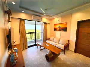 una sala de estar con un sofá y una mesa en Vintage 2BHK Apartment - Gym, Pool & Amenities - Mangrove View, en Candolim