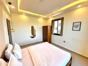 Un dormitorio con una cama y una ventana en Vintage 2BHK Apartment - Gym, Pool & Amenities - Mangrove View, en Candolim