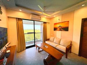 una sala de estar con un sofá y una mesa en Vintage 2BHK Apartment - Gym, Pool & Amenities - Mangrove View, en Candolim