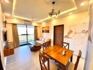 坎多林Vintage 2BHK Serviced Apartment with Gym, Pool & Amenities - Mangrove Views的客厅配有桌子和墙上的地图