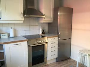 a kitchen with a stove and a refrigerator at Lingonberry Cottage in Ekenäs