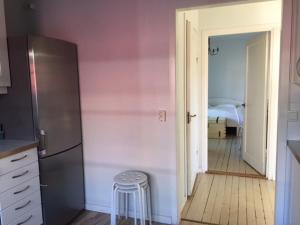 a kitchen with a refrigerator and a stool in a room at Lingonberry Cottage in Tammisaari