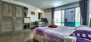 a bedroom with a bed and a large window at Pension Zum Ross in Karon Beach +9 photos