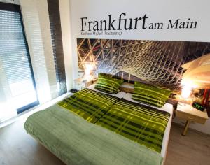 a green bed with green pillows in a bedroom at Boardinghouse-Ebenhausen in Ebenhausen Werk