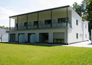 ein großes weißes Gebäude mit grünem Rasen in der Unterkunft Boardinghouse-Ebenhausen in Ebenhausen Werk