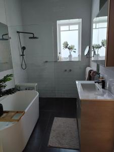 a bathroom with a tub and a sink at Elegant Art Deco Gem Cosy 3BR Retreat in Carnegie +36 photos