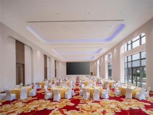 a large banquet hall with white tables and white chairs at Holiday Inn Resort Wanning Shenzhou Peninsula by IHG in Wanning +47 photos