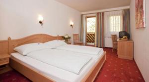 ホッホフィルツェンにあるWarmingerhofの部屋にある大きな白いベッドのある寝室