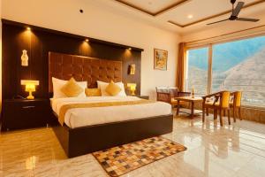 a bedroom with a large bed and a table and chairs at The kempty Fall Resort, Mussoorie - Lavish & Luxury Stay in Mussoorie +34 photos