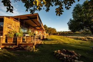 a wooden building with a porch on a grass field at ECO Lodge Villa Villekula in The Crags