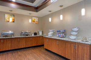 a large kitchen with wooden cabinets and marble counter tops at Comfort Suites Little Rock West in Little Rock +37 photos