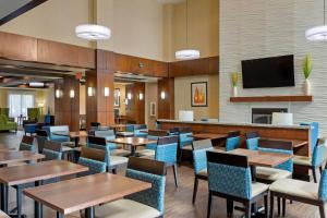 a restaurant with tables and chairs and a flat screen tv at Comfort Suites Little Rock West in Little Rock