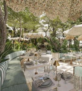 a restaurant with tables and chairs and trees at The IMPERIAL Vung Tau Hotel in Vung Tau