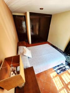 a small bedroom with a bed and a table at Room with Parking near the Center in Guanajuato