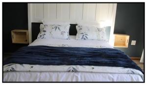 a bed with a blue blanket and pillows on it at brand st 95 in Brandfort